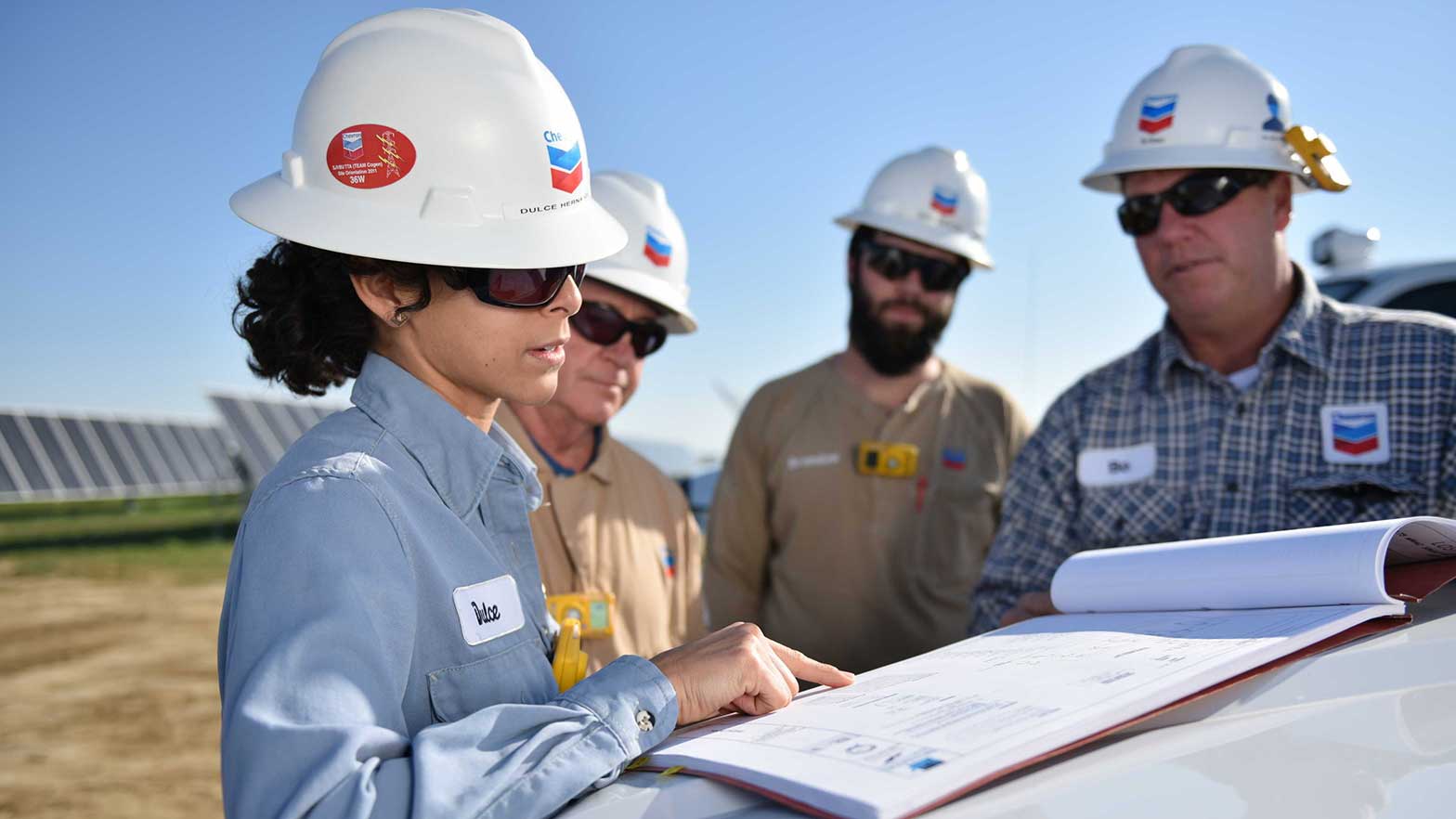 looking over a document, a group of workers discuss next steps