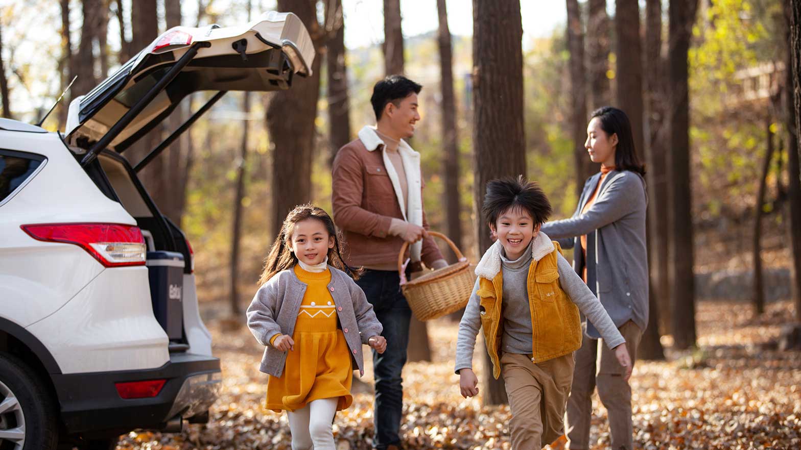 A family gather their items from the car and go on a hike