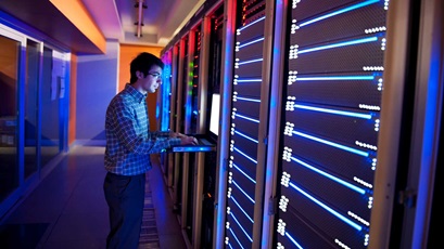 worker typing in information on large computer boards