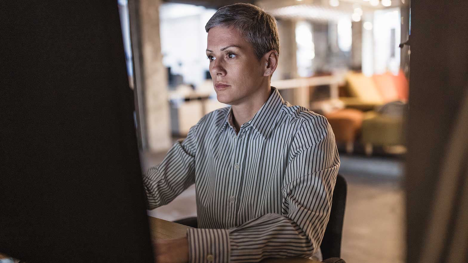 woman sitting at a computer looking at a webpage