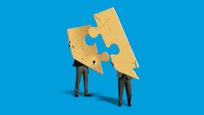 Two people holding up puzzle pieces