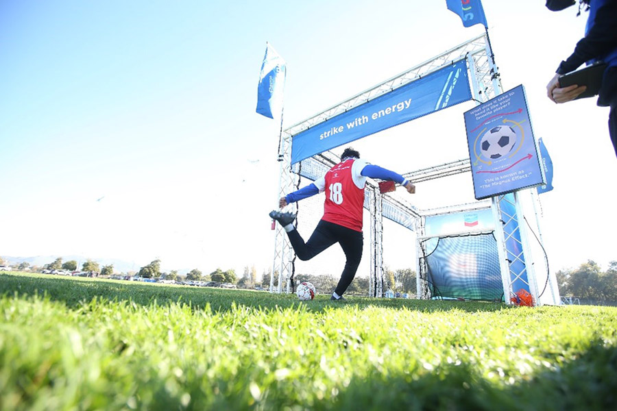football player kicking ball under strike with energy banner