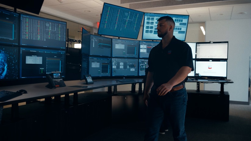 Worker walking around looking at computer monitors